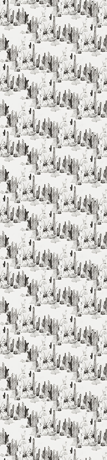 A roll of black and white wallpaper featuring a pattern with cacti and desert elements from drop it MODERN.