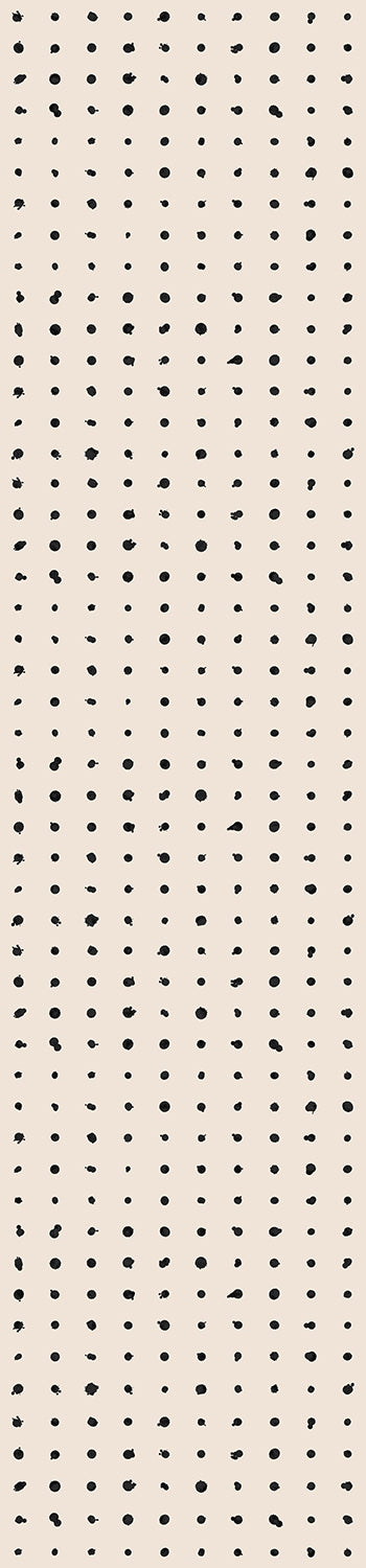 A rolled up wallpaper showing a dotted pattern with black dots on a creme background from drop it MODERN.
