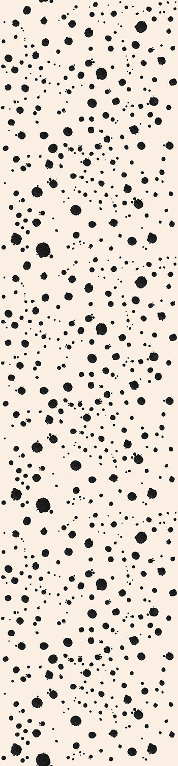 A roll of wallpaper featuring a black speckled pattern on a beige background from drop it MODERN.