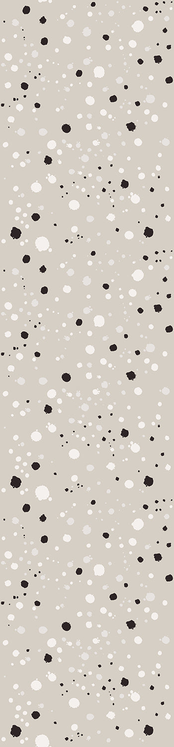 A roll of wallpaper with a modern ink drop pattern in shades of grey and white from drop it MODERN.