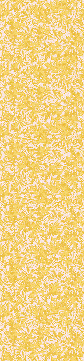 A rolled-up wallpaper showing a floral pattern with yellow and white colors from drop it MODERN.